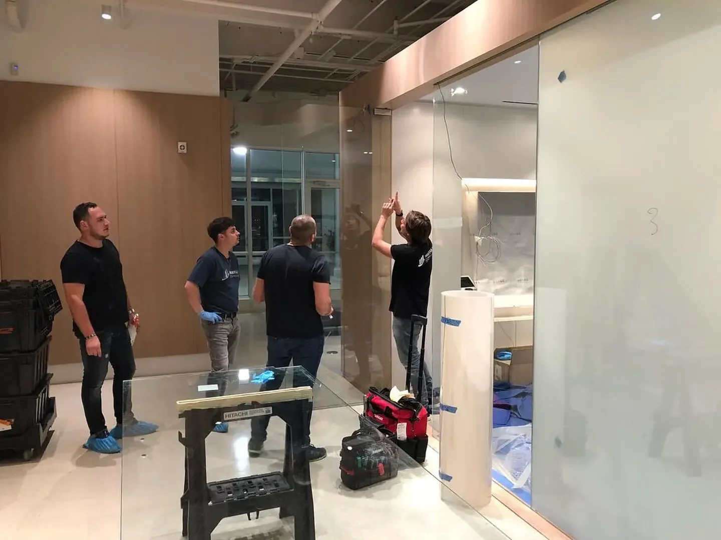 Smart Glass Technologies installation crew fitting an interior glass partition